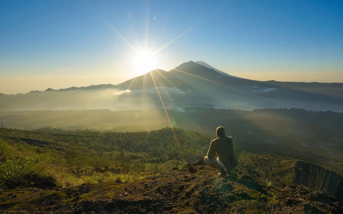 The Mount Batur caldera in warm evening light with the lake dark below the rim