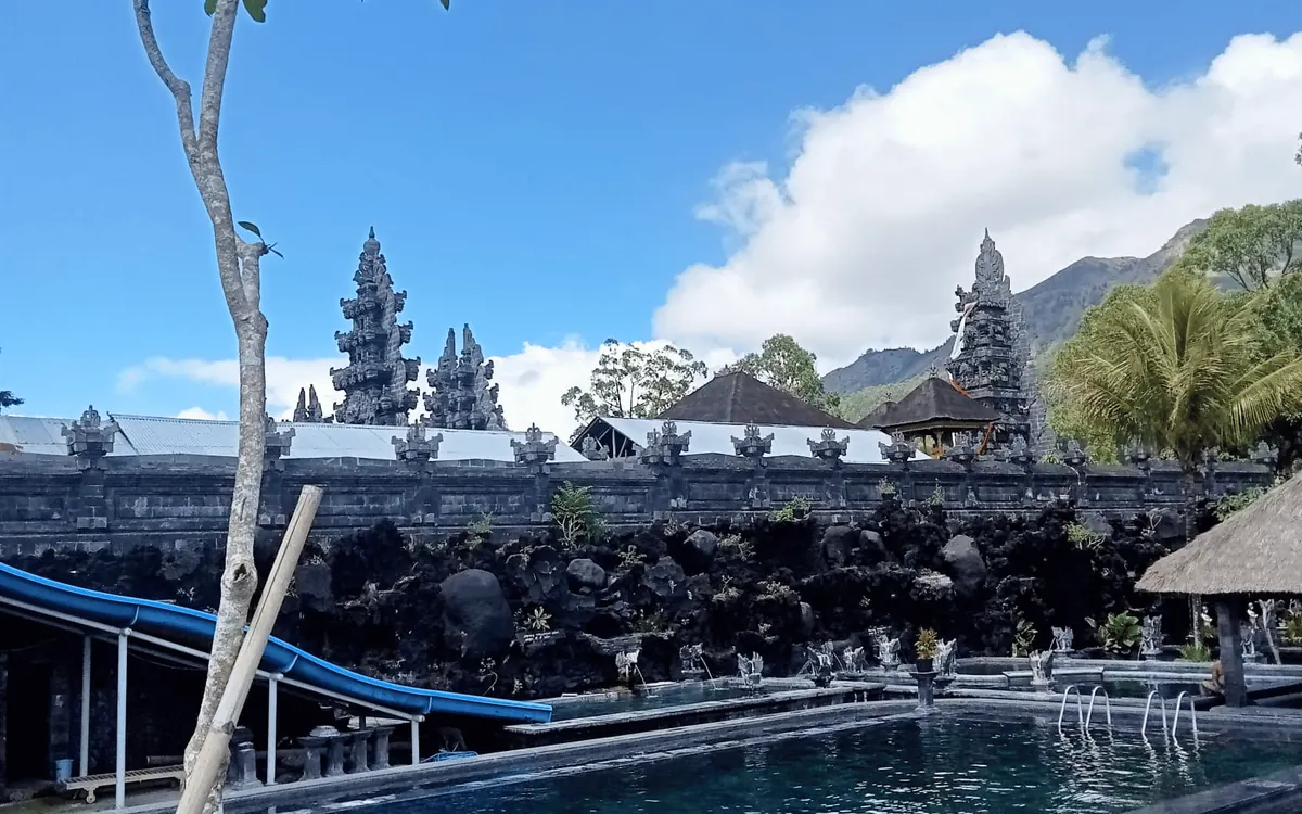 A warm natural pool on the shore of Lake Batur with the volcano behind it