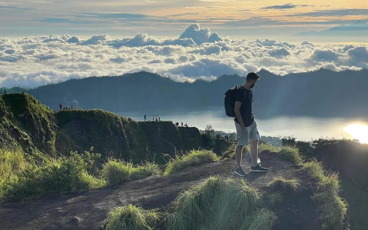 Walkers in fleeces and headtorches on the dark slope of Mount Batur before sunrise
